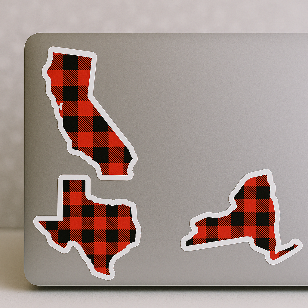 Laptop with red and black checkered state-shaped stickers on a light gray background