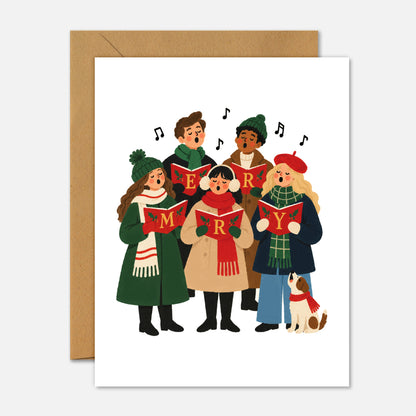 A white greeting card featuring a colorful illustration of a choir of children singing with musical notes, shown with a brown kraft envelope behind it on a light gray background.
