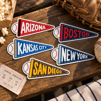 Baseball-themed pennant-shaped vinyl stickers with team names arranged on a rustic wooden surface with baseball props.