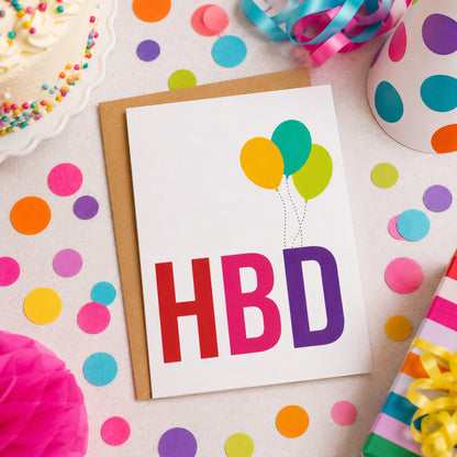 HBD Happy Birthday Greeting Card featuring bold colorful HBD lettering with three festive balloons on a white background.