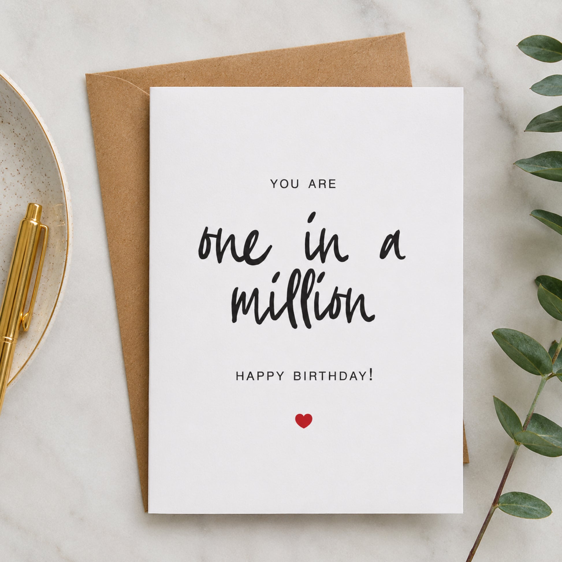 One in a Million birthday card with black hand lettered text and small red heart on a white card with kraft envelope.