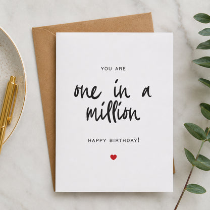 One in a Million birthday card with black hand lettered text and small red heart on a white card with kraft envelope.
