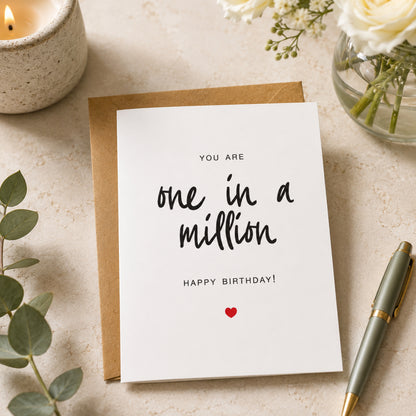 One in a Million birthday card with black hand lettered text and small red heart on a white card with kraft envelope.