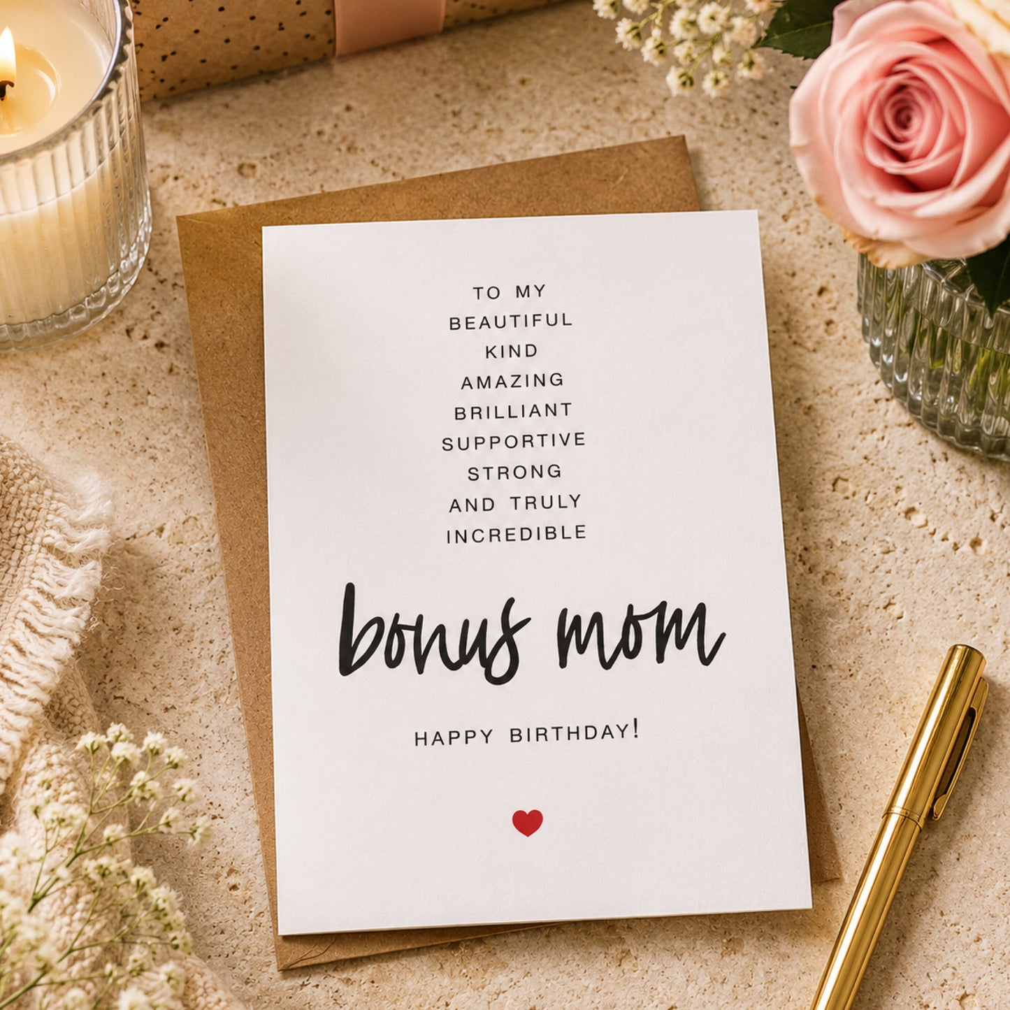 Bonus Mom birthday card with heartfelt black typography and a small red heart on a white greeting card with kraft envelope.
