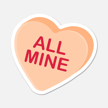 Heart-shaped candy with 'ALL MINE' text on a light gray background