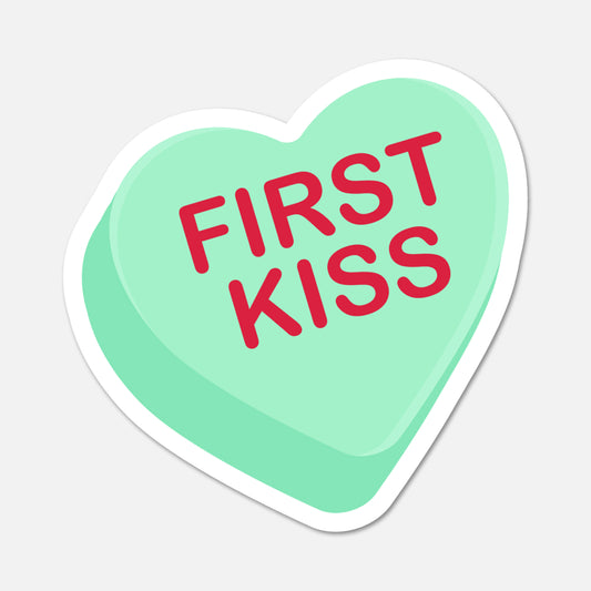 Heart-shaped sticker with 'FIRST KISS' text on a light gray background