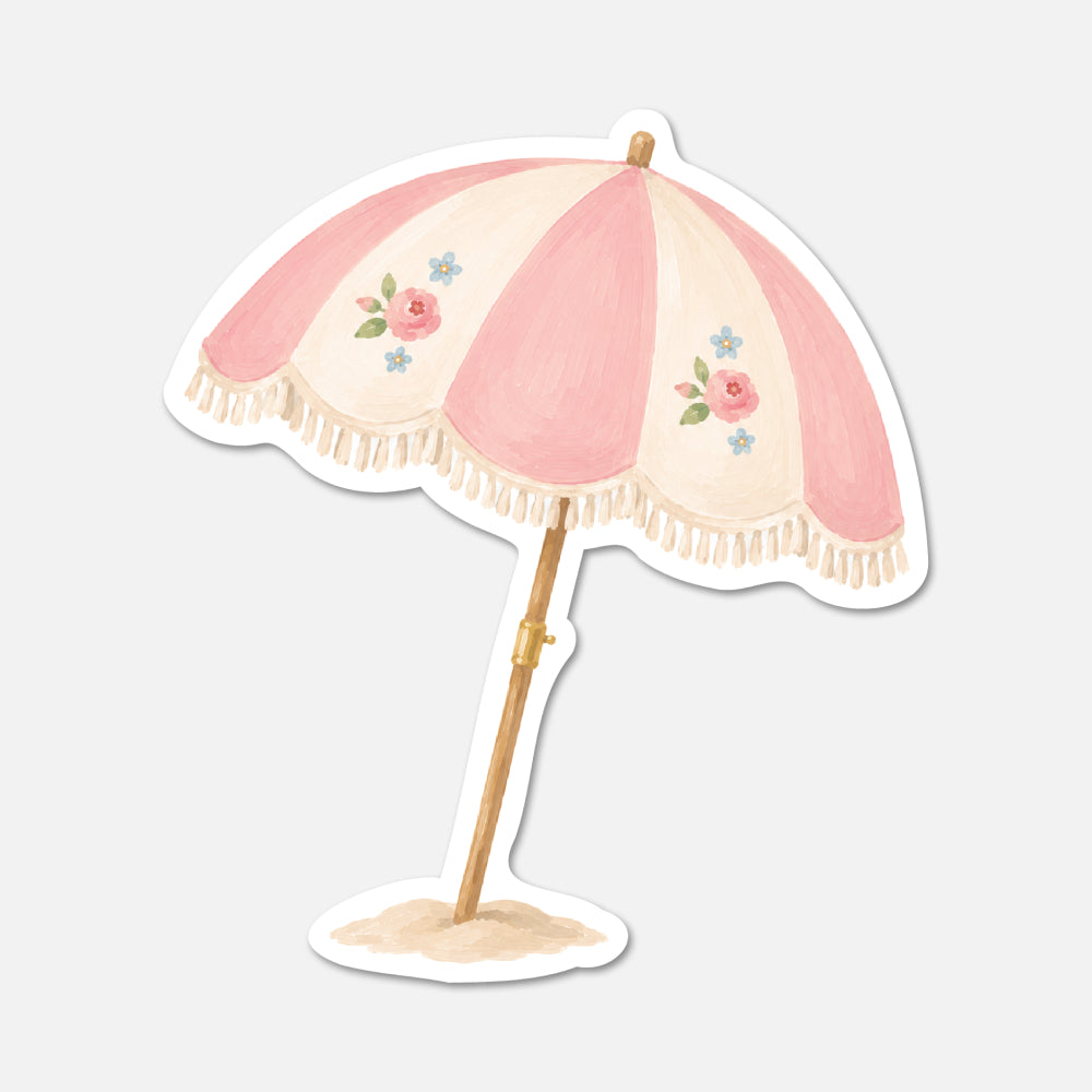 Decorative beach umbrella with pink canopy and floral patterns on a light gray background