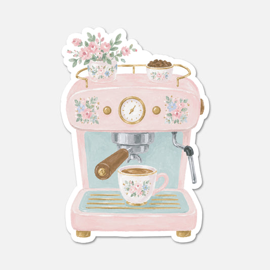 A die-cut sticker featuring a retro-style pink espresso machine with floral details, a cup of coffee, and small decorative pots, shown on a light gray background.