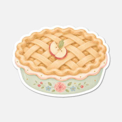 A die-cut sticker featuring a watercolor-style illustration of a lattice-top apple pie with a pale green base decorated with pink and blue flowers, shown on a light gray background.