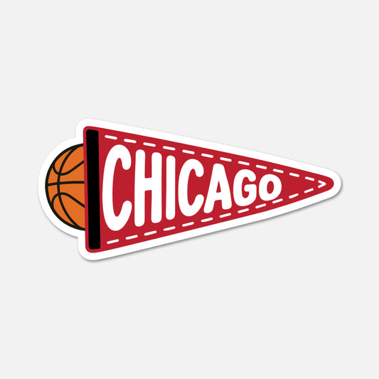 A die-cut sticker or decal shaped like a red football-style pennant with white dashed stitching, the word "CHICAGO" in large white letters, and an orange basketball partially visible on the left, shown on a light gray background.