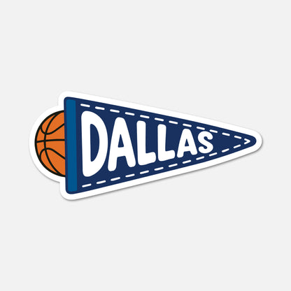 A die-cut sticker shaped like a navy blue sports pennant with the word "DALLAS" in large white letters, plus a partial orange basketball peeking out from behind on the left, shown on a light gray background.