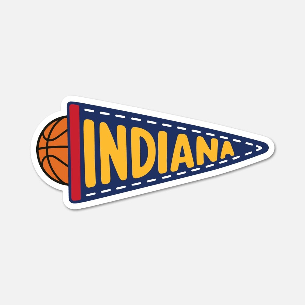 A die-cut sticker of a sports pennant featuring the word 'INDIANA' in yellow letters on a navy blue background, with a basketball peeking out from behind the left edge and a white border.