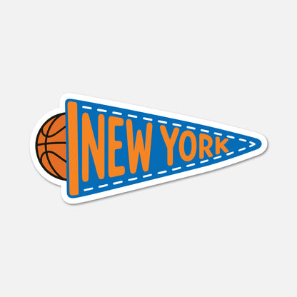 A die-cut sticker shaped like a blue sports pennant with white dashed stitching, orange 'NEW YORK' lettering, and a basketball partially visible behind it, shown on a light gray background.