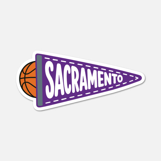 A die-cut sticker featuring a purple triangular pennant with the word 'SACRAMENTO' in white outlined letters, attached to an orange basketball, shown on a light gray background.