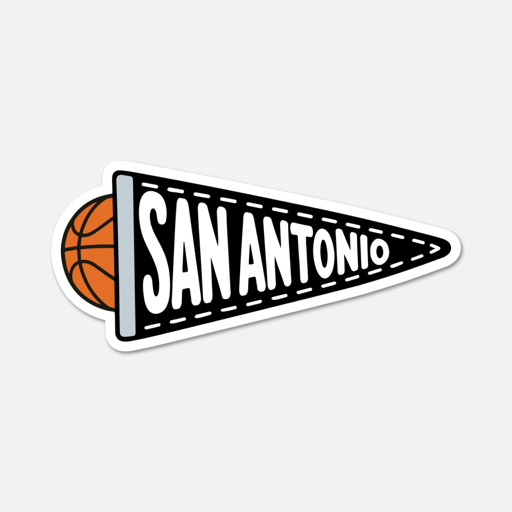 A die-cut sticker shaped like a black and white San Antonio basketball-themed pennant, with an orange basketball partially visible behind the left edge, shown on a light gray background.