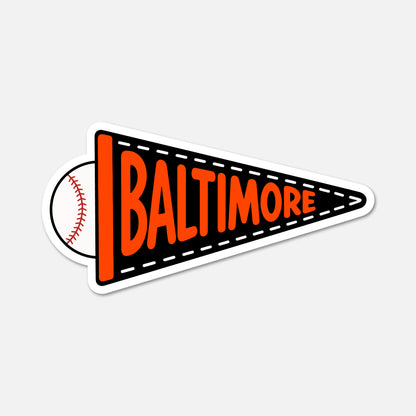 A die-cut sticker shaped like a black and orange pennant with the word 'BALTIMORE' in orange and a baseball graphic on the left side, shown on a light gray background.