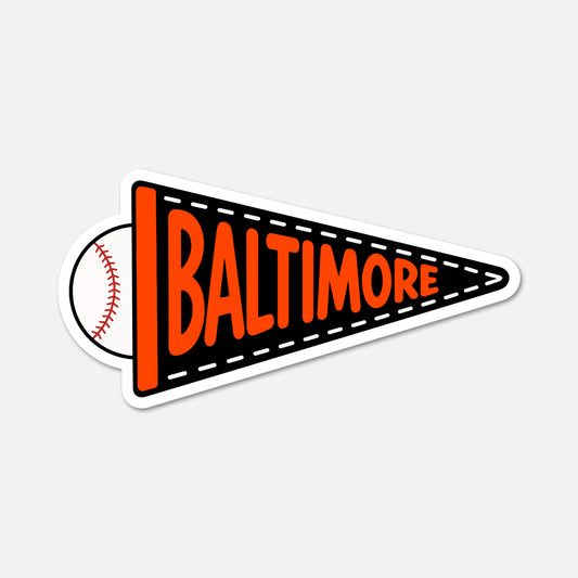 A die-cut sticker shaped like a black and orange pennant with the word 'BALTIMORE' in orange and a baseball graphic on the left side, shown on a light gray background.