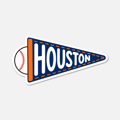 A die-cut sticker shaped like a sports pennant, featuring the word 'HOUSTON' in large white letters on a navy blue background with an orange side stripe. A baseball graphic peeks out from behind the left side of the pennant.