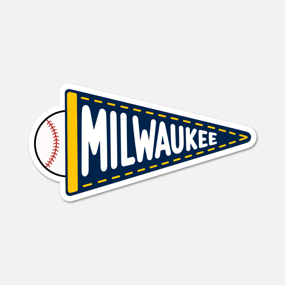 A die-cut sticker shaped like a Milwaukee sports pennant, featuring a navy blue pennant with yellow trim, white 'MILWAUKEE' lettering, a yellow vertical stripe, and a baseball peeking out from behind on the left, shown on a light gray background.