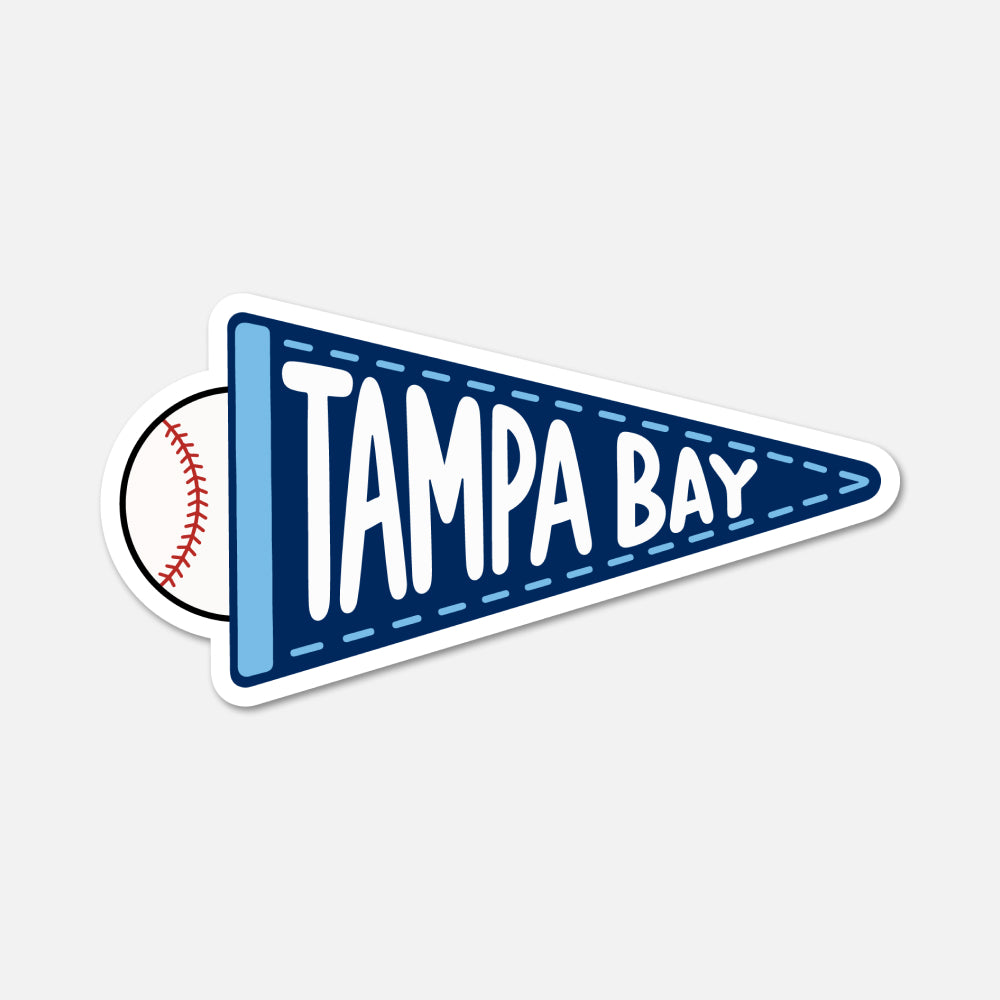 A die-cut sticker shaped like a Tampa Bay sports pennant, featuring a dark blue pennant with white 'TAMPA BAY' lettering, a light blue stripe, a baseball graphic on the left, and a white border, shown on a light gray background.