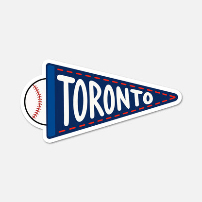 A die-cut sticker shaped like a navy blue sports pennant with the word TORONTO in large white letters and a baseball partially visible behind it, shown on a light gray background.