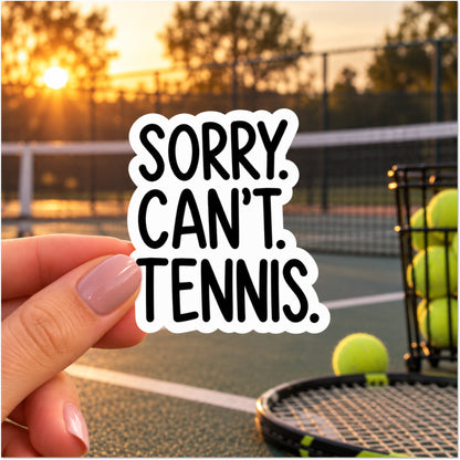 A hand holds a die-cut sticker that reads 'SORRY. CAN'T. TENNIS.'