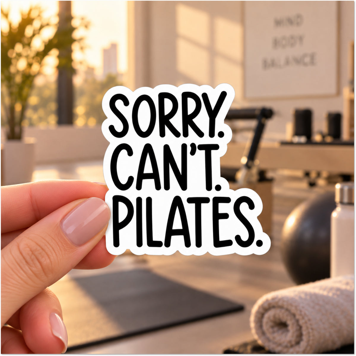 A hand holds a die-cut sticker with the text 'SORRY. CAN'T. PILATES.'