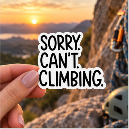 A hand holds a die-cut sticker that reads 'SORRY. CAN'T. CLIMBING.'