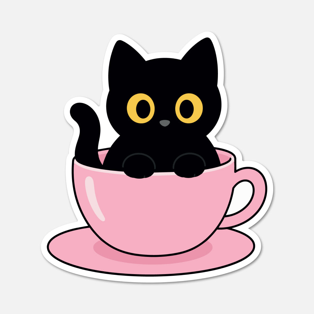 A die-cut sticker featuring a cute cartoon black cat with yellow eyes sitting inside a pink teacup on a matching saucer, shown on a light gray background.