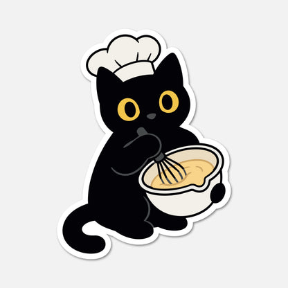 A die-cut sticker featuring a cartoon black cat wearing a white chef's hat and whiskering a bowl of yellow batter, shown on a light gray background.
