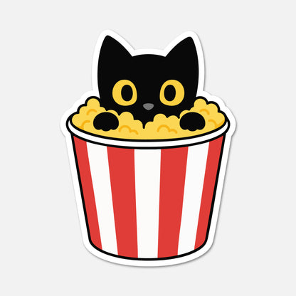 A die-cut sticker featuring a cute cartoon black cat peeking out of a red-and-white striped popcorn bucket filled with yellow popcorn, shown on a light gray background.