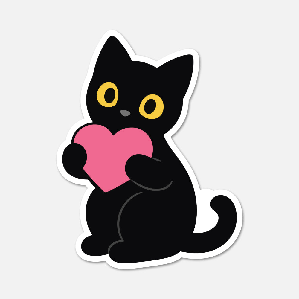 A die-cut sticker featuring a cartoon black cat with yellow eyes holding a pink heart, shown on a light gray background.