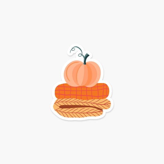 Pile of blankets with a pumpkin on top 3.25 x 2.6 in - Fall & Autumn Sticker - Footnotes Paper